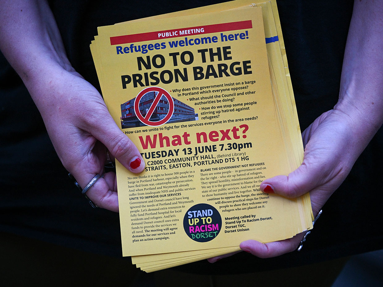 Campaigners hand out ‘Refugees welcome here, not the prison barge' leaflets after the public meeting with the Home Office over the migrant barge on June 06, 2023, in Portland, England. 