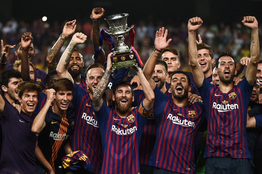 FC Barcelona FC's Argentinian forward Lionel Messi carries the cup of joy as they celebrate winning the Spanish Super Cup final 2-1 against Sevilla FC in Tangiers, Morocco, on August 12, 2018.