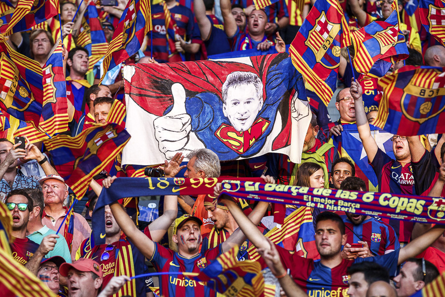 Spectators wave a huge mural of Lionel Messi as Superman during the UEFA Champions League final match between Barcelona and Juventus on June 6, 2015, in Berlin, Germany