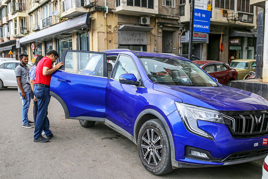 (File photo) Customers browse a Mahindra & Mahindra Ltd.'s XUV 700 Sports Utility Vehicle (SUV) parked along a street outside a company's dealership in Mumbai, India, on Wednesday, Aug. 3, 2022. Image: Dhiraj Singh/Bloomberg