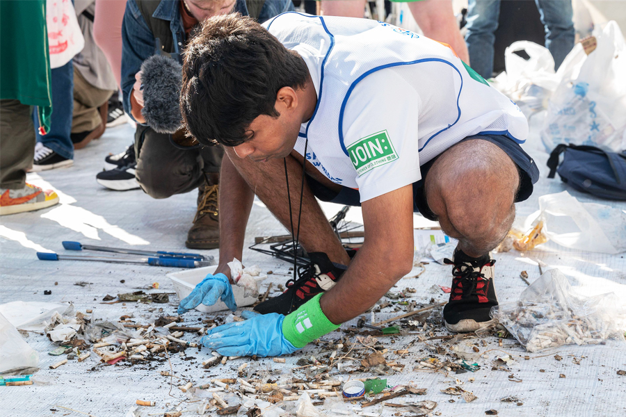  A member of India sorts through rubbish at the end of the first round of the 