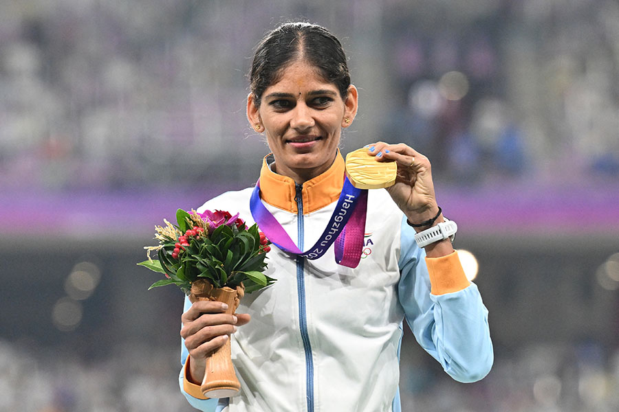 Gold medallist India's Parul Chaudhary celebrates on the podium during the medal ceremony for the women's 5,000m final athletics event during the 2022 Asian Games in Hangzhou in China's eastern Zhejiang province on October 3, 2023. Image: Hector Retmal / AFP 