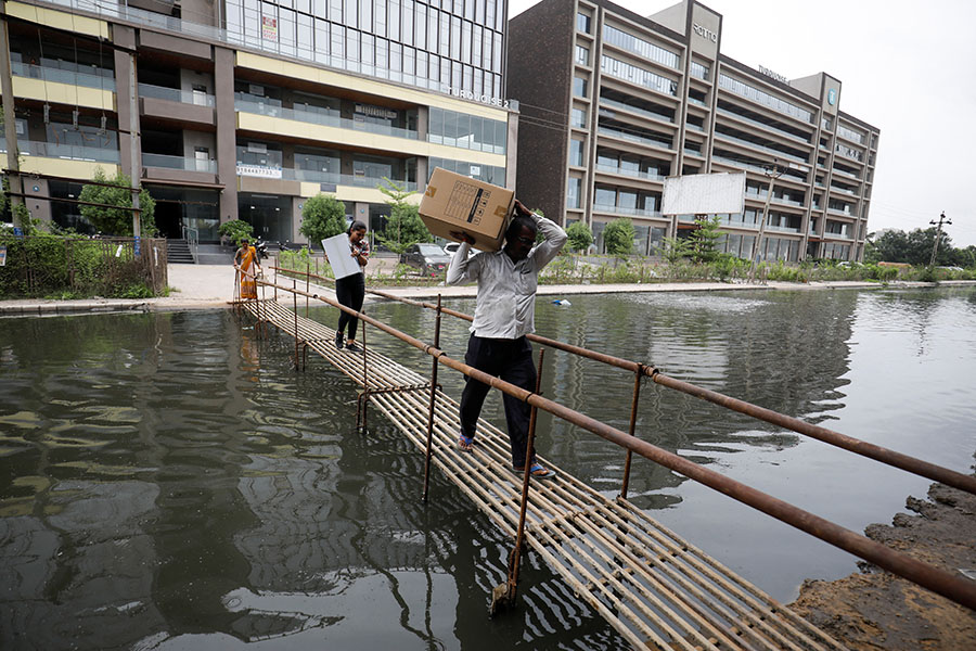 
People walk on a makeshift bridge above a waterlogged street in Ahmedabad Image: Amit Dave/ Reuters