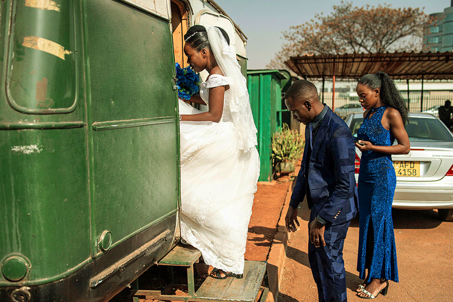 A bride and groom enter a wedding gown rental shop inside a caravan at the Magistrates Court in Harare. Image: JOHN WESSELS / AFP