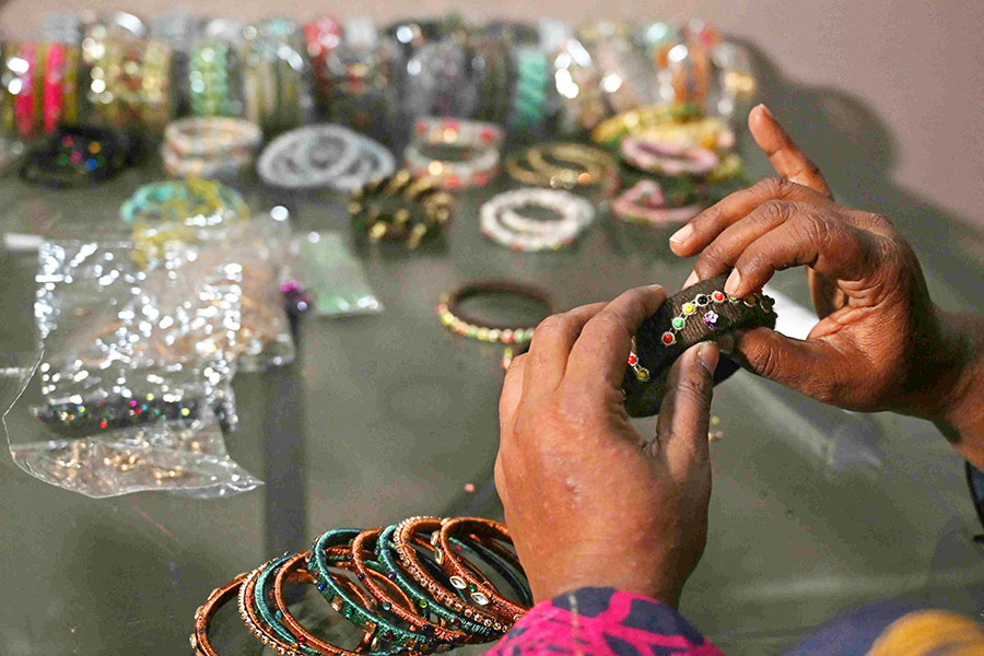 Talat Zahid adds decorative elements to bangles at a home workshop in Hyderabad. <br>Image: Asif Hassan / AFP©