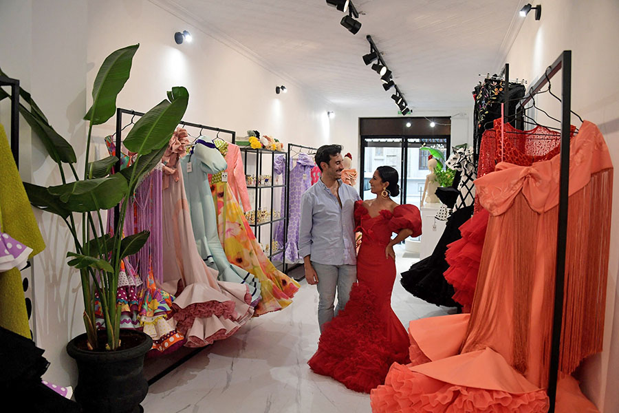 Luis Fernandez's workshop in Seville's Old City is buzzing with customers who have come to try on his dazzling array of flamenco dresses. Image: Cristina Quicler/AFP

