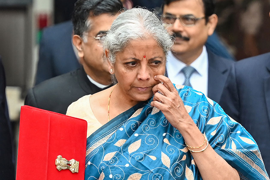  India's Finance Minister Nirmala Sitharaman holds the briefcase containing the annual budget documents as she leaves the Finance ministry with her staff to present the budget in the parliament in New Delhi on February 1, 2024. (Photo by Sajjad HUSSAIN / AFP)