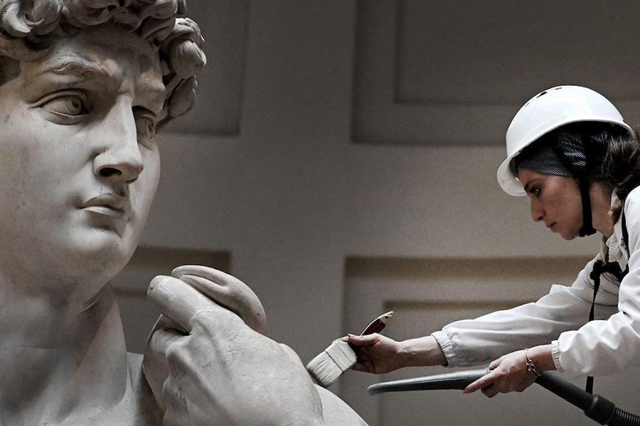 Italian restorer Eleonora Pucci cleans Michelangelo's statue of David using a backpack vacuum and synthetic fibre brush at the Galleria dell'Accademia, in Florence on February 19, 2024. Image: Tiziana Fabi/ AFP©