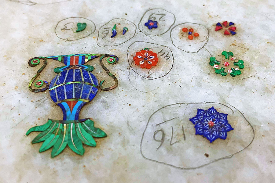 To commence the intricate marble inlay process, artisans first apply a Gerua colour to the marble, creating a striking contrast essential for outlining and inlay work. Image: Veidehi Gite 
