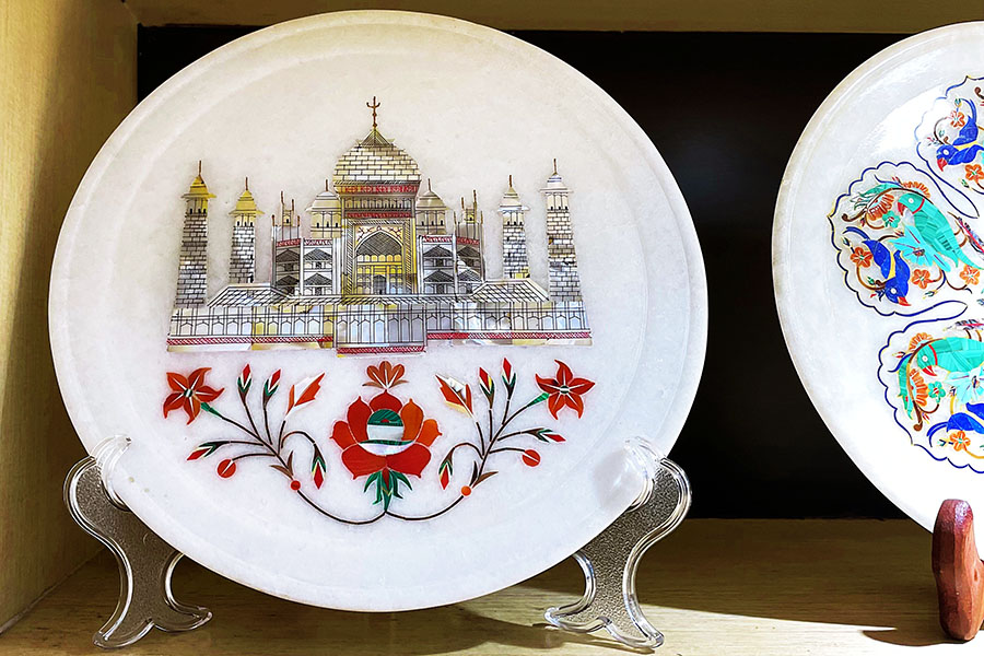 The art of Parchin Kari (marble inlay work) was introduced to India by Persian artisans, who decorated the walls of the Taj Mahal and various other Mughal monuments with this exquisite craft. A marble plate showcasing the intricate art of Parchin Kari, through a depiction of the Taj Mahal. Image: Veidehi Gite 
