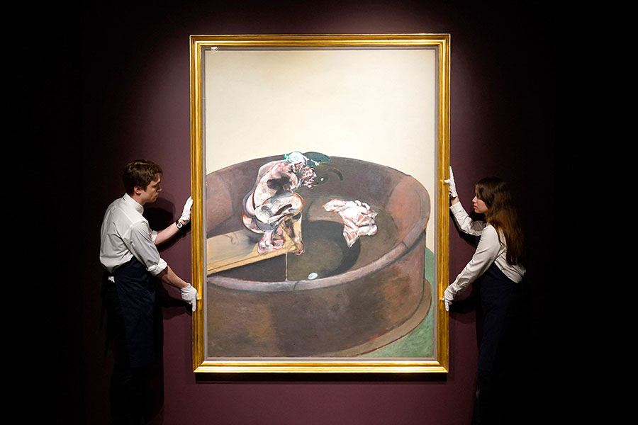 Sotheby’s art handlers hold Francis Bacon's “Portrait of George Dyer Crouching” during a media preview for Sotheby's 